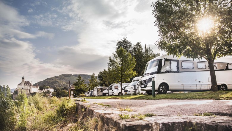 Camping vor Schloß Schönbühel, © Daniela Matejschek Wohnmobile auf einem Campingplatz mit Schloss Schönbühel im Hintergrund.