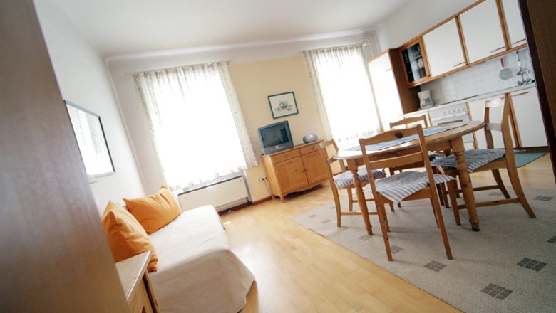 Haus Weissenbacher, © weinfranz.at Helles Wohnzimmer mit Sofa, Esstisch und Küchenzeile.