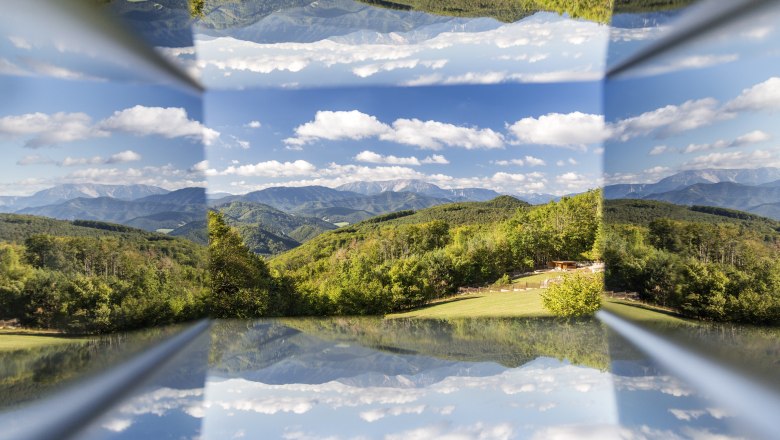 Blickplatz Waxeneckhaus, © Wiener Alpen, Foto: Franz Zwickl Spiegelung einer Berglandschaft mit blauem Himmel und Wolken.