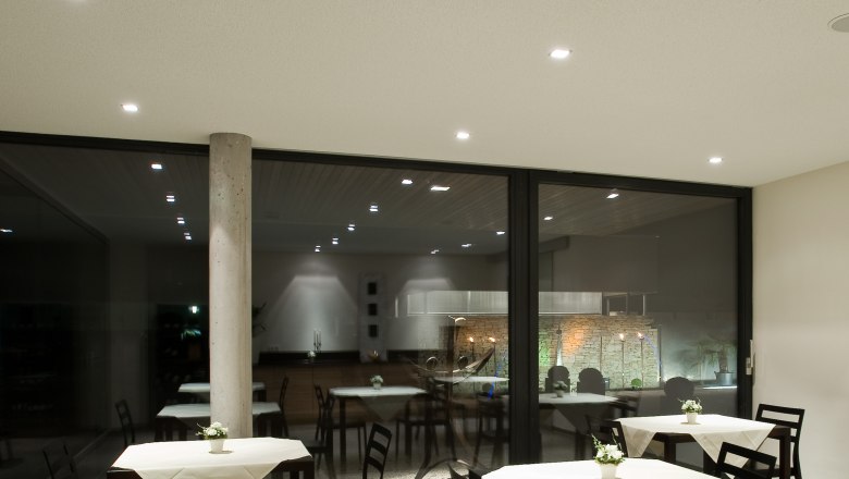 Frühstücksraum, © Rosenberger Moderner Frühstücksraum mit Tischen und Stühlen, dekoriert mit weißen Tischdecken und Blumen.