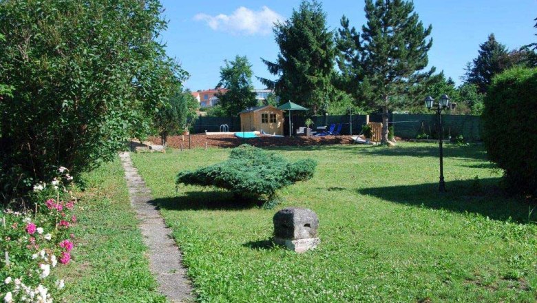 Frühstückspension Krieger, © Krieger Garten mit Rasen, Bäumen und einem kleinen Weg, der zu einem Holzhaus führt.