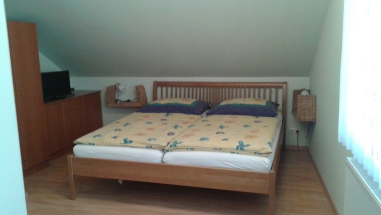 Dreibettzimmer (Doppelbett) bei Fam. Waysmayer, © © Bianca Waysmayer Ein Schlafzimmer mit einem Doppelbett, einem Schrank und einem Fernseher auf einem Schrank.