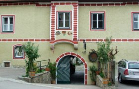 Freisingerhof, © Familie Leitner Historisches Gebäude mit Torbogen und roten Ziegeln.