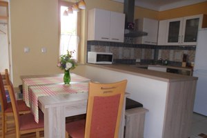 Küche und Wohnbereich, © Fam. Faber Ein moderner Küchen- und Essbereich mit Tisch, Stühlen und Küchengeräten.