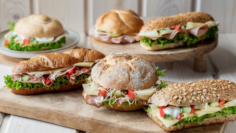 Snacks, © Koll GmbH Verschiedene belegte Brötchen auf Holzbrett arrangiert.