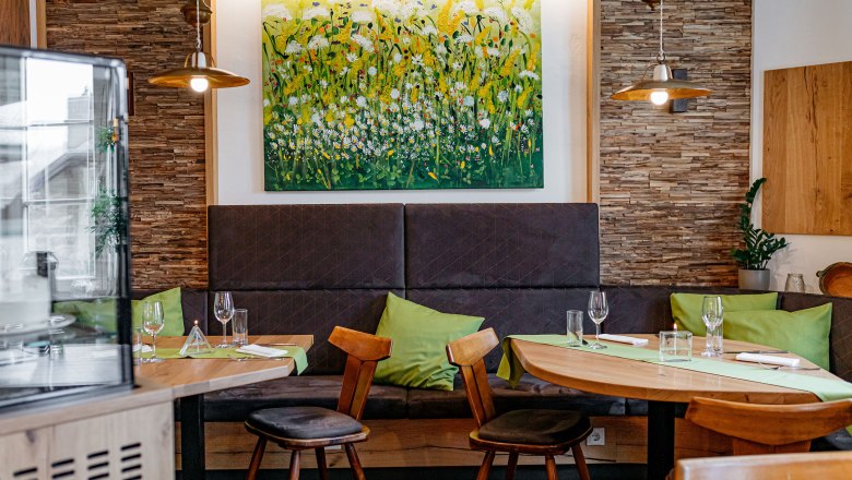 Gastzimmer mit liebevoll ausgewählten Details, © Niederösterreich Werbung/Mara Hohla Gemütliches Gastzimmer mit Holzmöbeln, grünen Kissen und einem Blumenbild an der Wand.