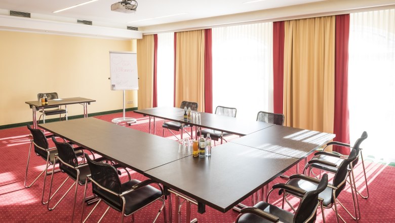 Hotel Karl-Wirt, © Hotel Karl-Wirt Konferenzraum mit U-förmigem Tisch, Stühlen, Flipchart und Projektor.
