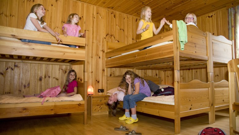 Zimmer, © Pension Bruckner Kinder spielen in einem Zimmer mit Holzstockbetten.
