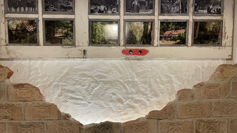 KlammWirtin, © KlammWirtin Alte Fenster mit historischen Fotos und Backsteinmauer.