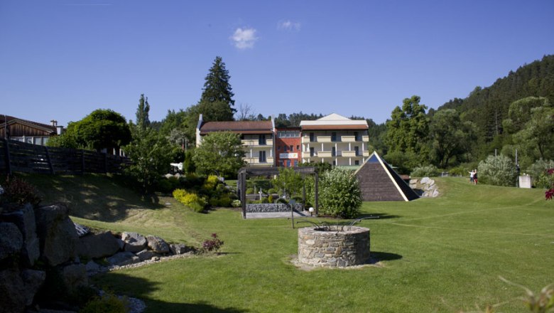 Energiebrunnen, © Hotel-Restaurant Liebnitzmuehle GmbH & Co KG Ein gepflegter Garten mit einem Brunnen im Vordergrund und einem Hotel im Hintergrund.