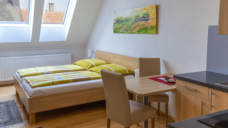 Doppelzimmer mit Küchenzeile, © BIO-Weingut Poys Doppelzimmer mit Küchenzeile, Bett, Tisch und Stühlen.