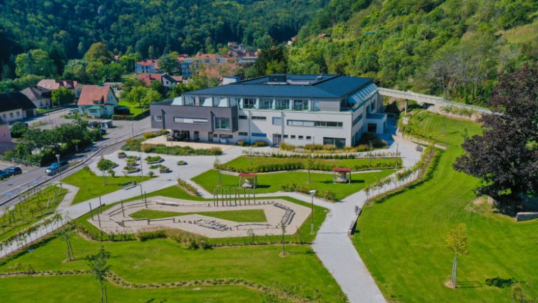 Nuhr Medical Center, © NMC Luftaufnahme eines modernen Gebäudes mit Garten, umgeben von grünen Hügeln.