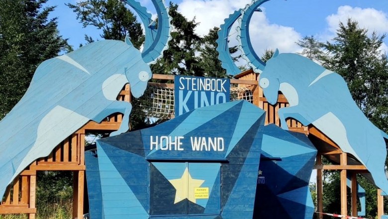 steinbock-kino-cnaturpark-hohe-wand, © Naturpark Hohe Wand Eingang des Steinbock Kinos im Naturpark Hohe Wand mit blauen Steinbock-Silhouetten.