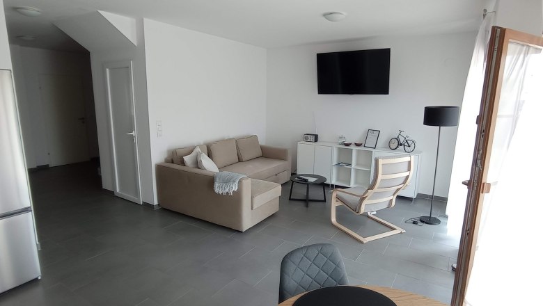 Lounge Michlfarm Wohnküche, © michlfarm Wohnzimmer mit beiger Couch und weißen Wänden