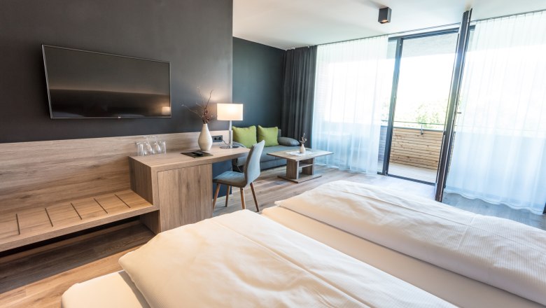 Zimmerbeispiel Weinlodge, © KASTNER NEW MEDIA - kastner.tv Modernes Hotelzimmer mit Doppelbett, Schreibtisch, Fernseher und Balkon.