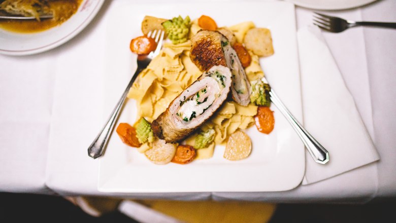 Nicht nur die Knödel sind zu empfehlen, © Niederösterreich Werbung/Mara Hohla Gefülltes Fleisch auf Nudeln mit Gemüse auf einem weißen Teller.