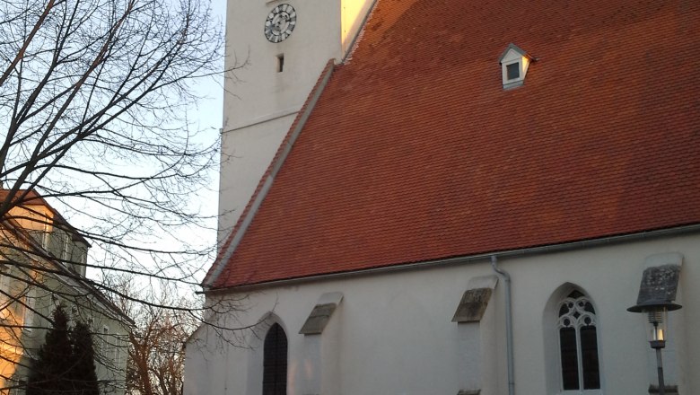 Kirche Kapelln, © Gemeinde Kapelln Kirche mit rotem Dach und Uhrturm in Kapelln bei Sonnenuntergang.