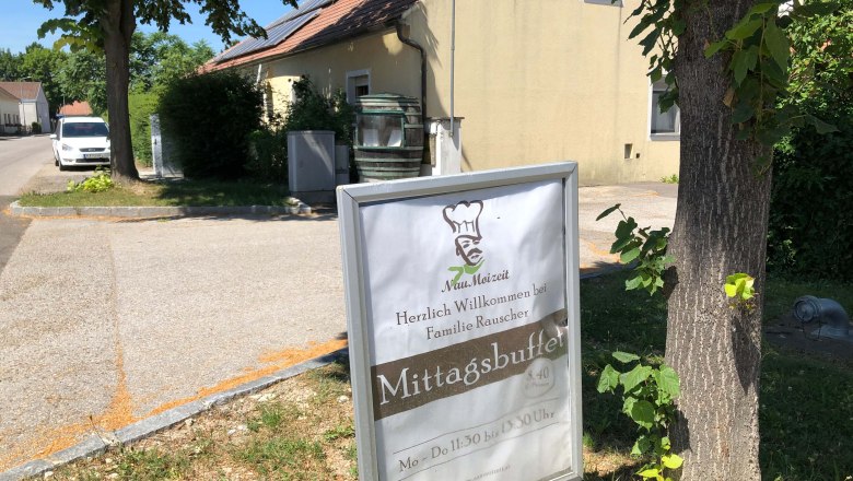 Fam. Rauscher, © Donau Niederösterreich Ein Schild vor einem Gebäude mit der Aufschrift 'Mittagsbuffet' und 'Herzlich Willkommen bei Familie Rauscher'.