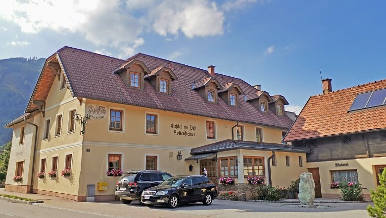 Täglich frisches Gebäck aus der hauseigenen Bäckerei, © Wiener Alpen Ein traditionelles Gasthaus mit Bäckerei und geparkten Autos davor.