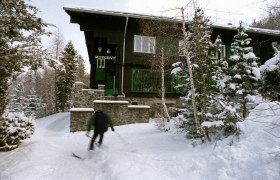 Looshaus im Winter, © Looshaus - Christian Redtenbacher Ein Skifahrer fährt an einem verschneiten Gebäude vorbei, das als Restaurant dient.