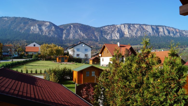 Aussicht von der Panoramatreppe, © Reep Blick auf Häuser mit roten Dächern und Berge im Hintergrund bei klarem Himmel.