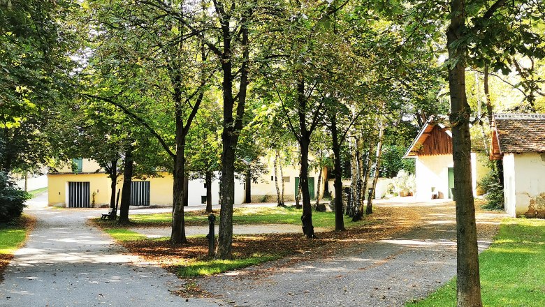 Rasten - chillen - und die Ruhe genießen, © Weinstraße Weinviertel Ein ruhiger Park mit Bäumen und kleinen Gebäuden im Hintergrund.
