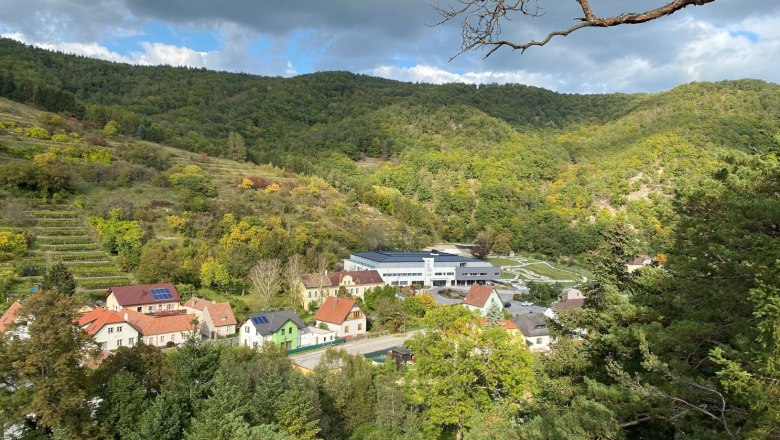 Ausblick vom Joschi-Felsen, © Stefan Seif Blick vom Joschi-Felsen auf ein Dorf mit Häusern und bewaldeten Hügeln im Hintergrund.