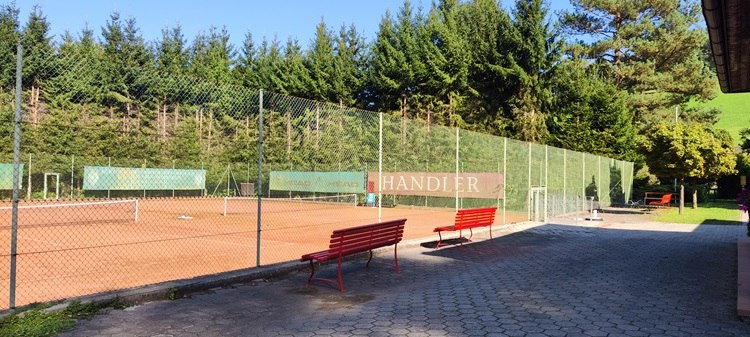 Tennis Bad Schönau, © Wiener Alpen Tennisplatz mit rotem Sand und Bänken in Bad Schönau.