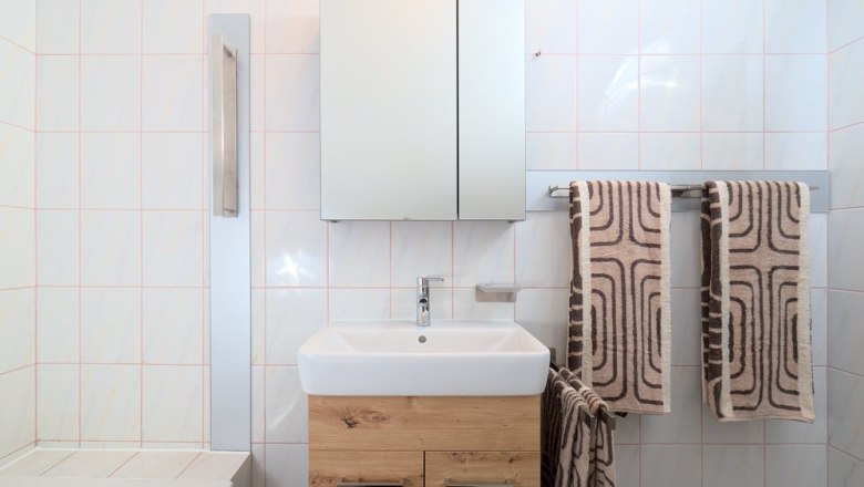 Badezimmer, © Jessica Brunnthaler Modernes Badezimmer mit Waschbecken, Spiegel und Handtüchern.