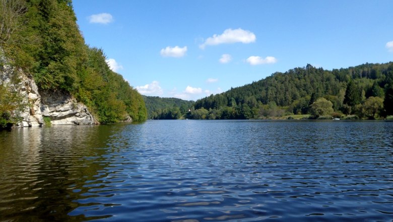 Stausee Thurnberg, © OEFG 1880 Ein ruhiger See umgeben von bewaldeten Hügeln unter blauem Himmel mit wenigen Wolken.