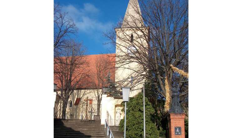 Pfarrkirche, © Gemeinde Altlichtenwarth Pfarrkirche mit Turm und roten Dachziegeln, umgeben von Bäumen und Treppen im Vordergrund.