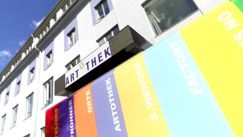 Aussenansicht Artothek, © Birgit und Peter Kainz Außenansicht eines Gebäudes mit Artothek-Schild und bunten Streifen.