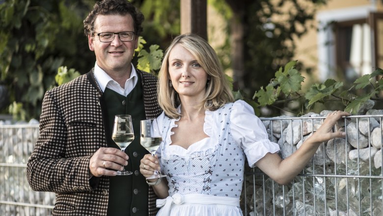 Sonja und Markus Oßberger, © Nino Zimmerhackl Ein Mann und eine Frau in traditioneller Kleidung halten Weingläser in der Hand.