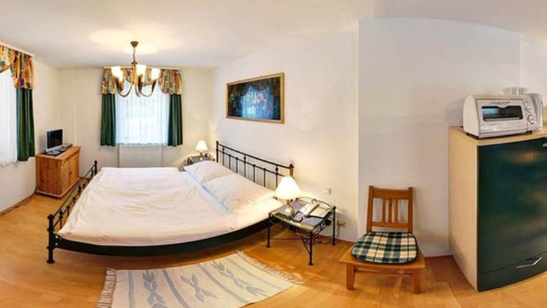 Wohnung 30m², © Haus Lenz Kleines Schlafzimmer mit Doppelbett, Nachttischen, TV, Mikrowelle und Stuhl.