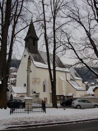 Pfarrkirche, © Matricula Online Eine Kirche im Winter mit schneebedecktem Boden und kahlen Bäumen.