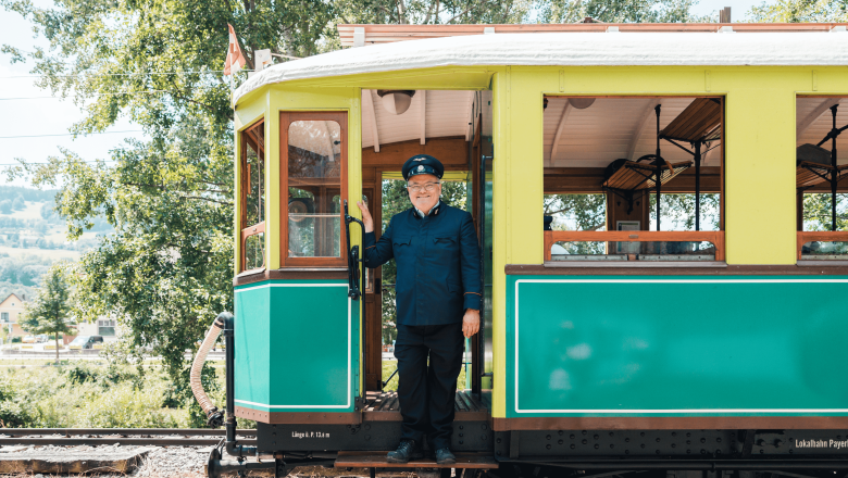 Höllentalbahn, © Österreich Werbung/Stefan Strasser Ein Zugführer in Uniform steht lächelnd in der Tür eines historischen Zuges.