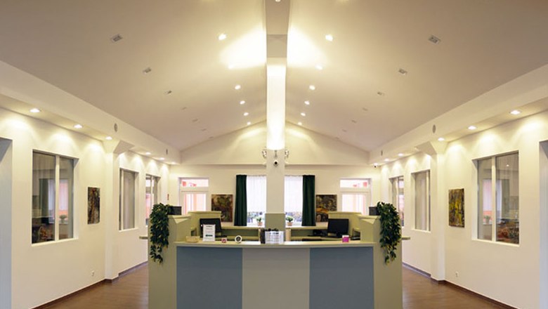 winrooms_02, © Winrooms Betriebs GmbH Modernes Empfangsbüro mit Schreibtisch und Pflanzen.