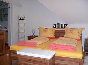 Ferienwohnung Stiefelbauer, © Fam. Stiefelbauer Gemütliches Schlafzimmer mit Doppelbett und gelb-roter Bettwäsche.