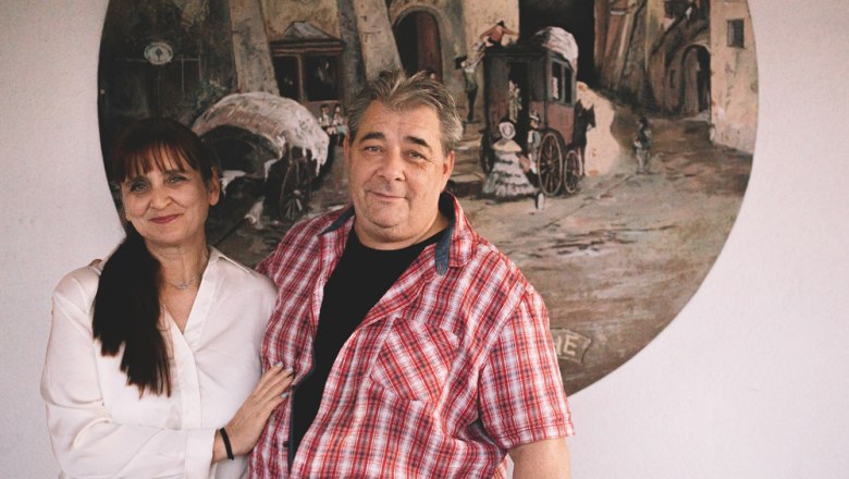 Wirtsleute Alexandra Turek & Christian Vlasaty, © Niederösterreich Werbung/Mara Hohla Ein Mann und eine Frau stehen vor einem Gemälde an der Wand.