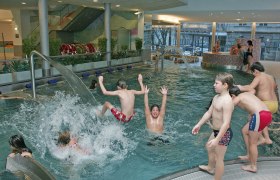Aquacity St. Pölten, © Aquacity St. Pölten Kinder spielen und planschen in einem Hallenbad mit Wasserspielen.