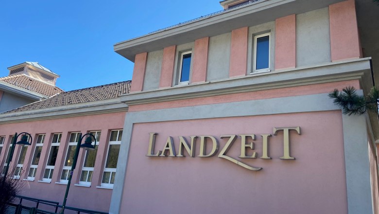 Landzeit Schottwien, © Wiener Alpen Gebäude mit rosa Fassade und dem Schriftzug 'Landzeit'.