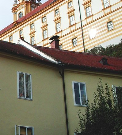 Ferienwohnung Zöchling mit Stift, © Hermann Zöchling Gelbes Gebäude mit rotem Dach vor einem Kloster.