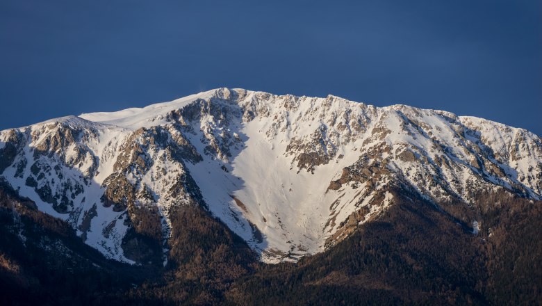 Hotel Schneeberghof, © Niederösterreich Werbung / Maximilian Pawlikowsky Schneebedeckter Berg unter blauem Himmel.
