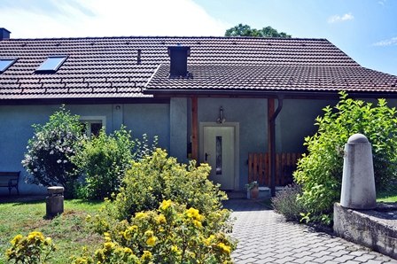 Eingang vom Parkplatz, © © Gästehaus Langthaler Eingang eines Hauses mit Garten und Pflanzen.