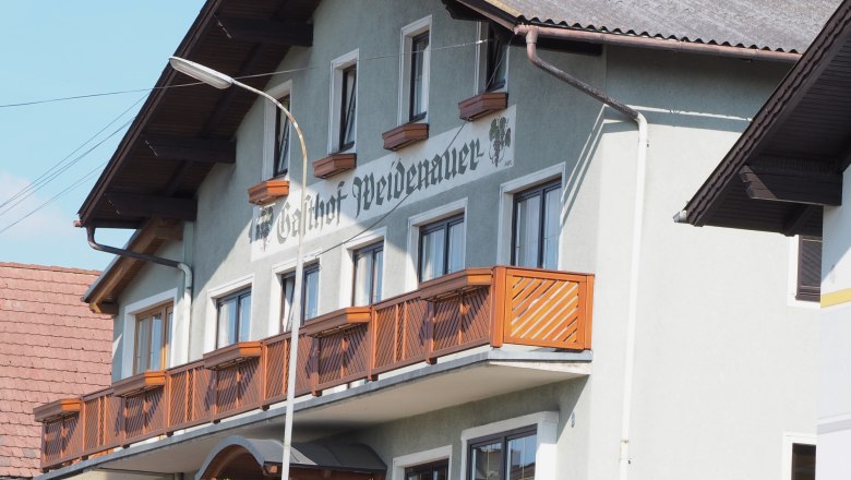 Gasthaus Weidenauer, © Marktgemeinde Sallingberg Außenansicht des Gasthofs Weidenauer mit Holzbalkon und grüner Hecke.