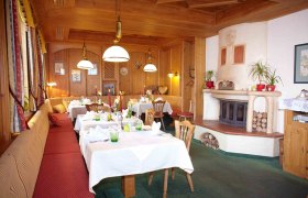 Kaminstüberl, © Familie Pichler Gemütlicher Raum mit Holzwänden, gedeckten Tischen und Kamin.