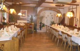 Privatzimmer Karl Mandl, © Familie Mandl Ein gemütlicher Speiseraum mit langen, gedeckten Tischen und Holzstühlen, dekoriert mit Lampen und Pflanzen.