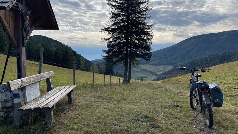 Blick nach Rohrbach, © Angelika Burger Landschaft mit Bank, Baum und Fahrrad auf einem Hügel mit Blick ins Tal.