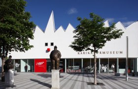 Karikaturmuseum Krems, © Christian Redtenbacher Außenansicht des Karikaturmuseums Krems mit Statuen und Bäumen.