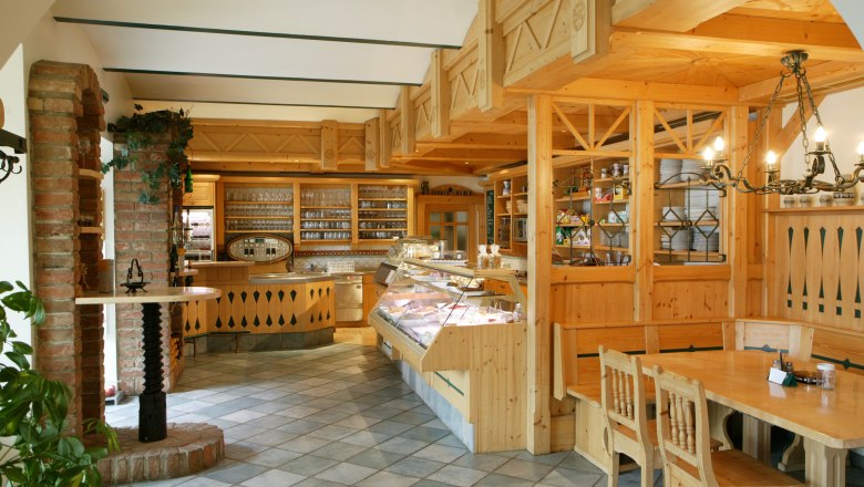 Heuriger Gilg, © Weingut Gilg Innenansicht eines traditionellen Heurigen mit Holzmöbeln und Theke.